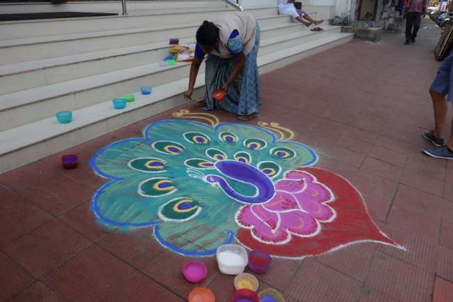 Ein Pfau aus Farbpulver schmückt einen Geschäftseingang zum tamilischen Neujahr